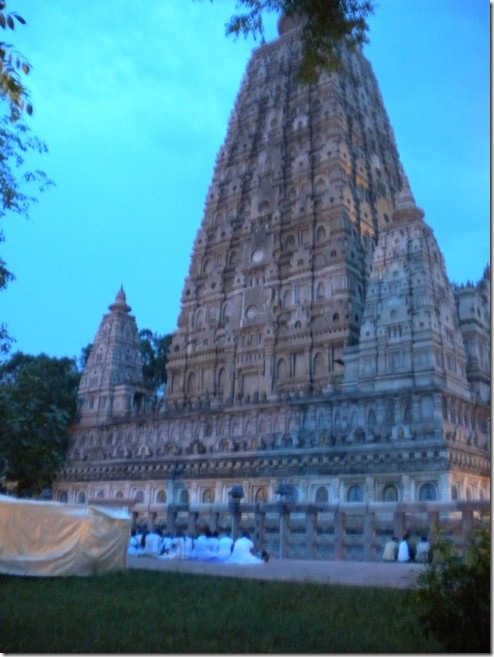 המקדש המרכזי בבודה-גאיה, במקום בו הבודהה זכה לנירוונה, לעת ערב, קבוצה של עולי רגל בודהיסטים מסרי-לנקה בבגדים לבנים למרגלותיו