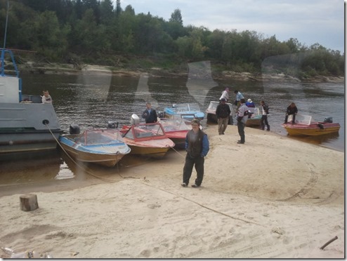 בני השבט וסירותיהם. שלא כמו הנשים, הגברים לבושים בגדים "רגילים" ולא מסורתיים בני השבט וסירותיהם. שלא כמו הנשים, הגברים לבושים בגדים "רגילים" ולא מסורתיים